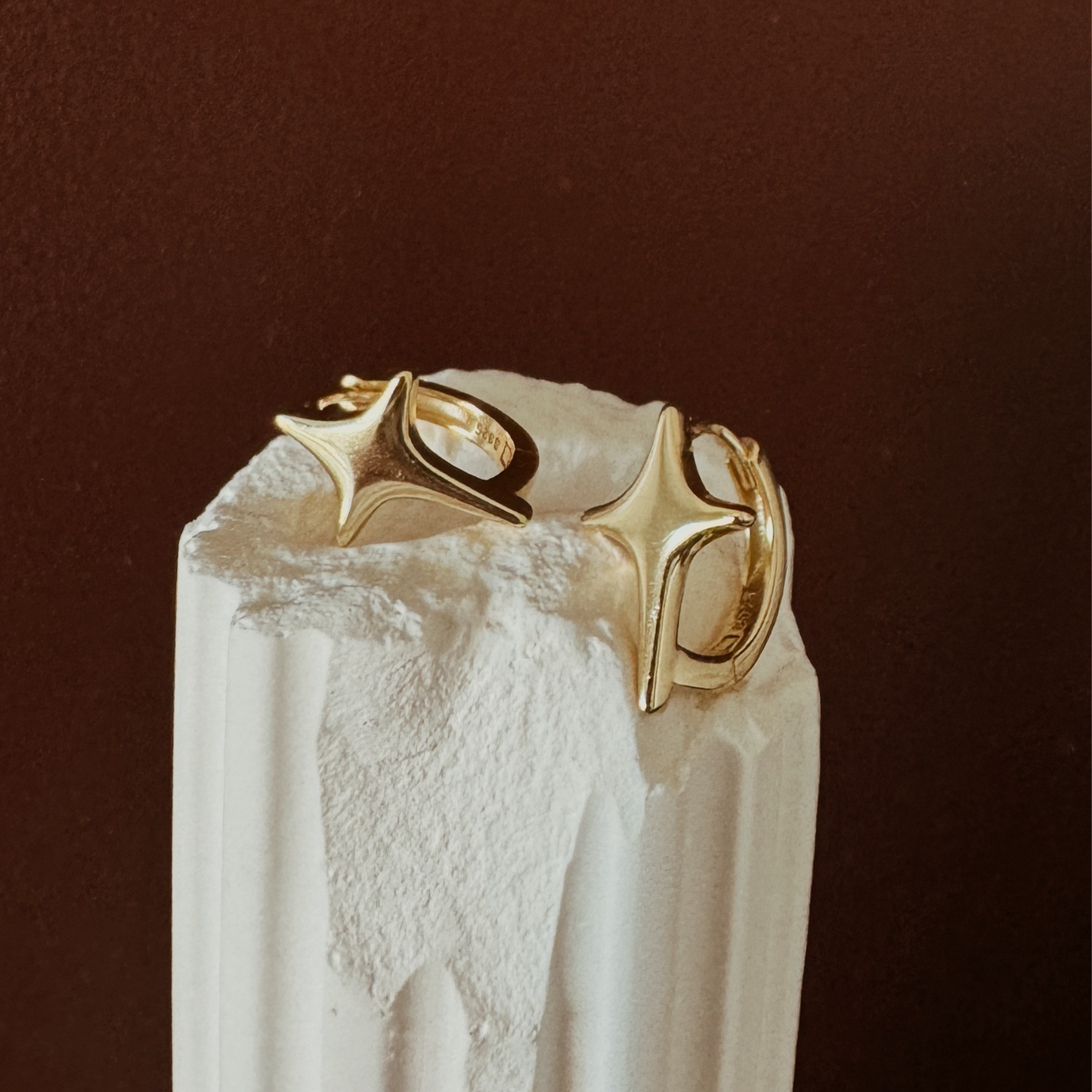 Gold hoop earrings with starburst design and polished finish