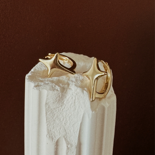 Gold hoop earrings with starburst design and polished finish