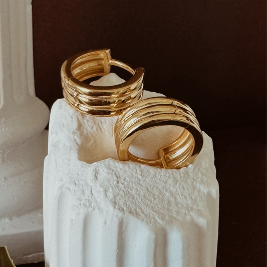 Small gold hoop earrings with ribbed texture and triple hoop design