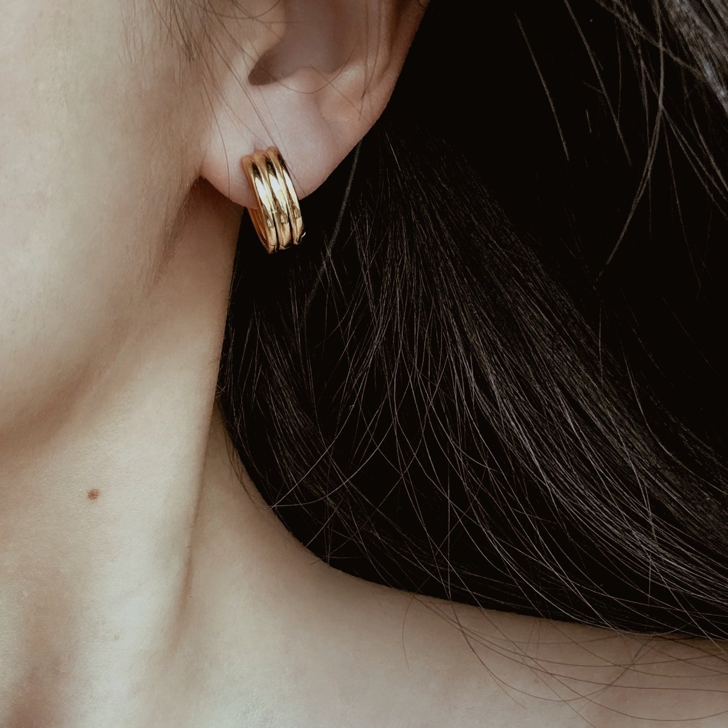 Small gold hoop earrings with ribbed texture and triple hoop design